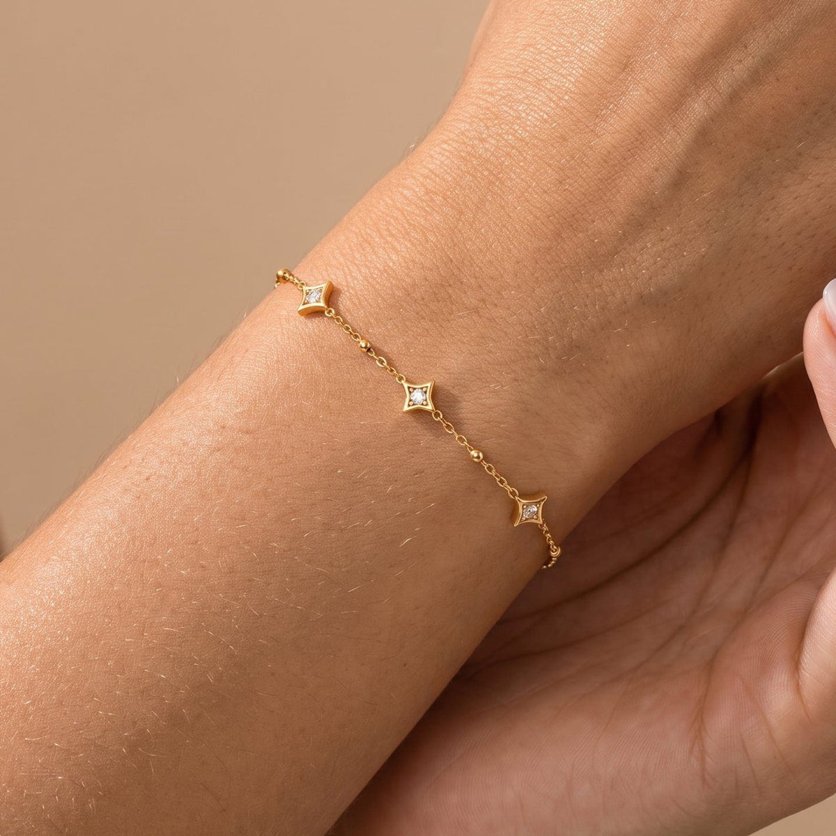 Woman wearing the Océane star station gold bracelet on the wrist