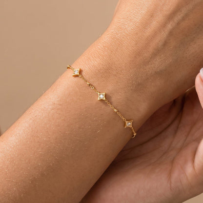 Woman wearing the Océane star station gold bracelet on the wrist