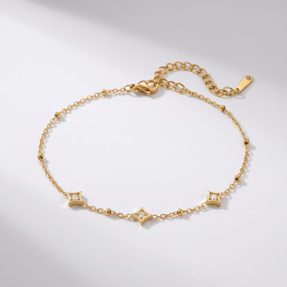 Océane star station gold bracelet on a white surface with soft directional shadows