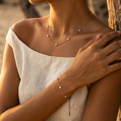 Woman in a linen top wearing the Océane star necklace, the matching bracelet on her wrist