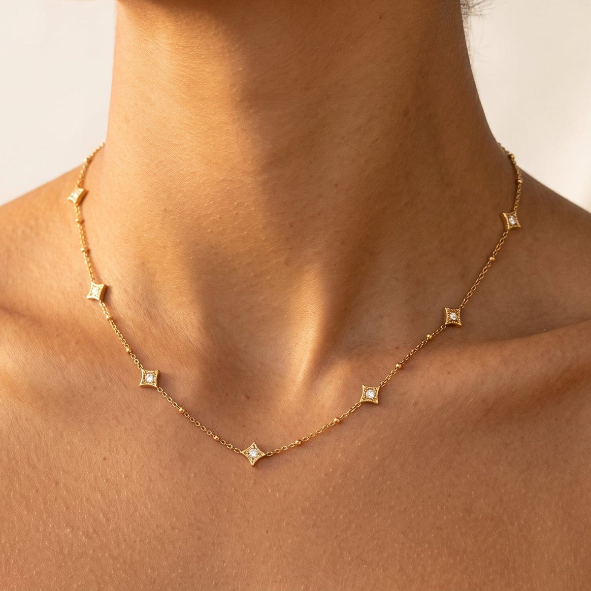 Woman wearing the Océane star station gold necklace at the collarbone