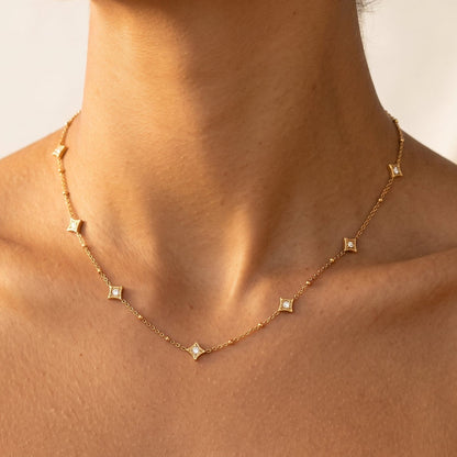 Woman wearing the Océane star station gold necklace at the collarbone