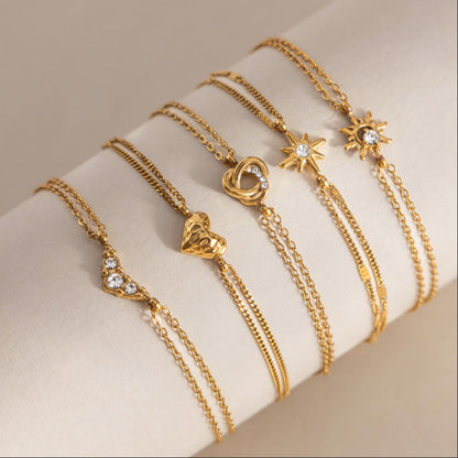Olivia crystal sun bracelet at the end of a row of five charm bracelets on a cream roll