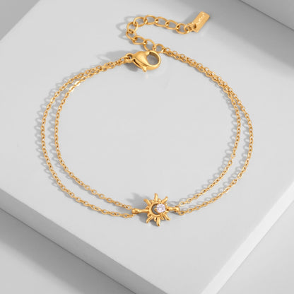 Olivia crystal sun gold bracelet on a white platform displaying the double chain and sun charm