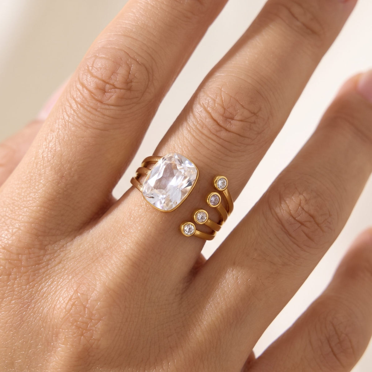 Close-up of the Olivia cushion crystal gold ring worn on a ring finger