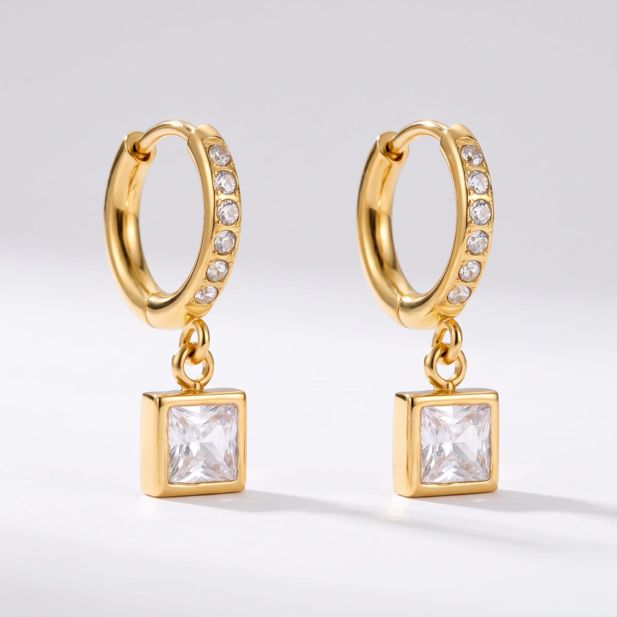 Paola crystal square gold earrings on a plain white background showing pave details
