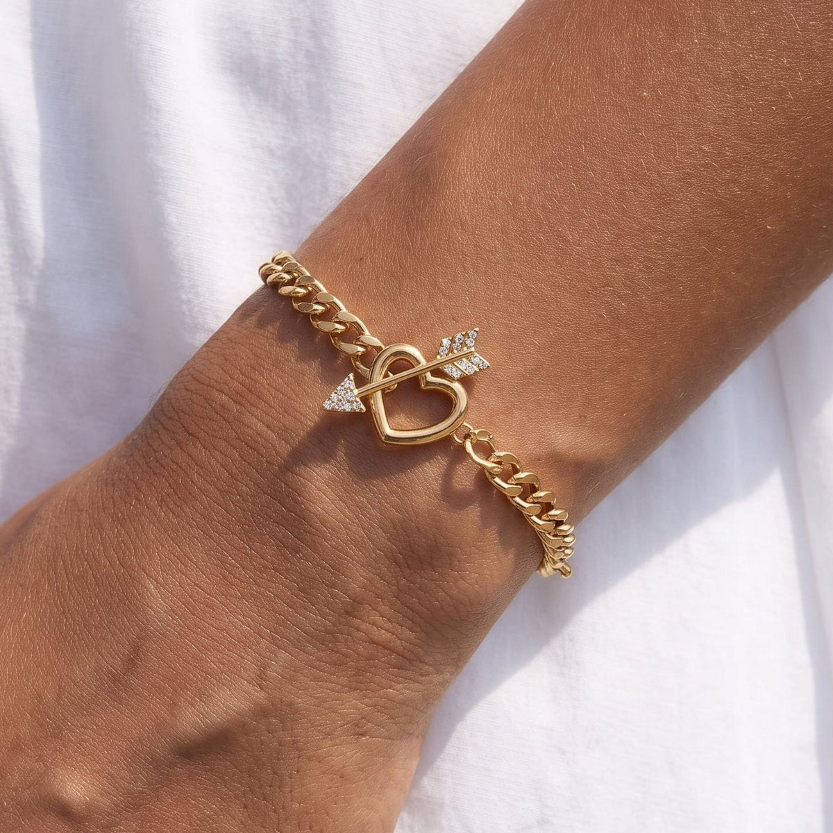Woman wearing the Rafaella heart arrow gold bracelet on the wrist
