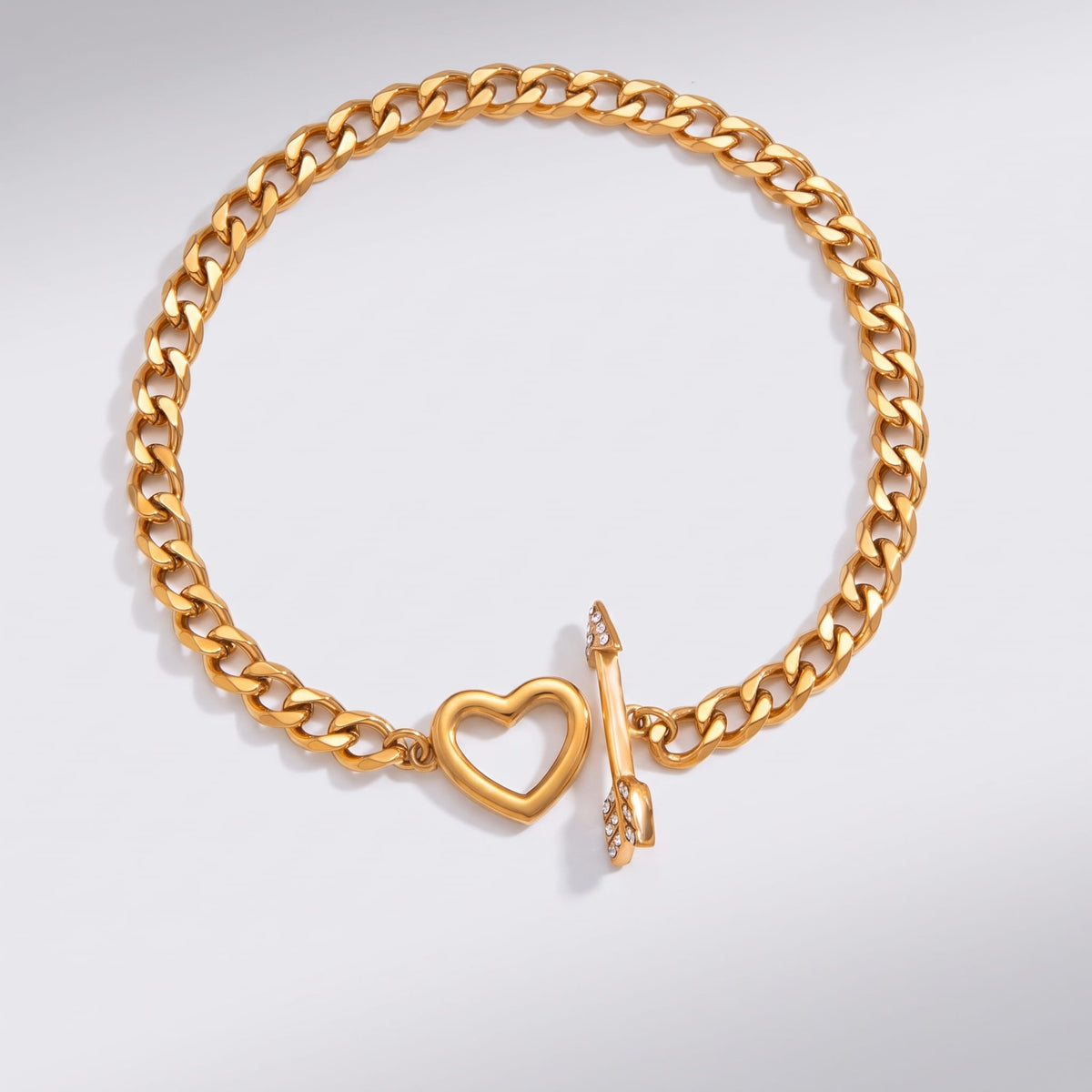Rafaella heart arrow gold bracelet on a plain white surface showing the open toggle clasp