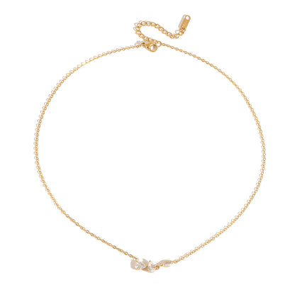 Rosalie pear cluster gold necklace laid flat with its extender chain on white