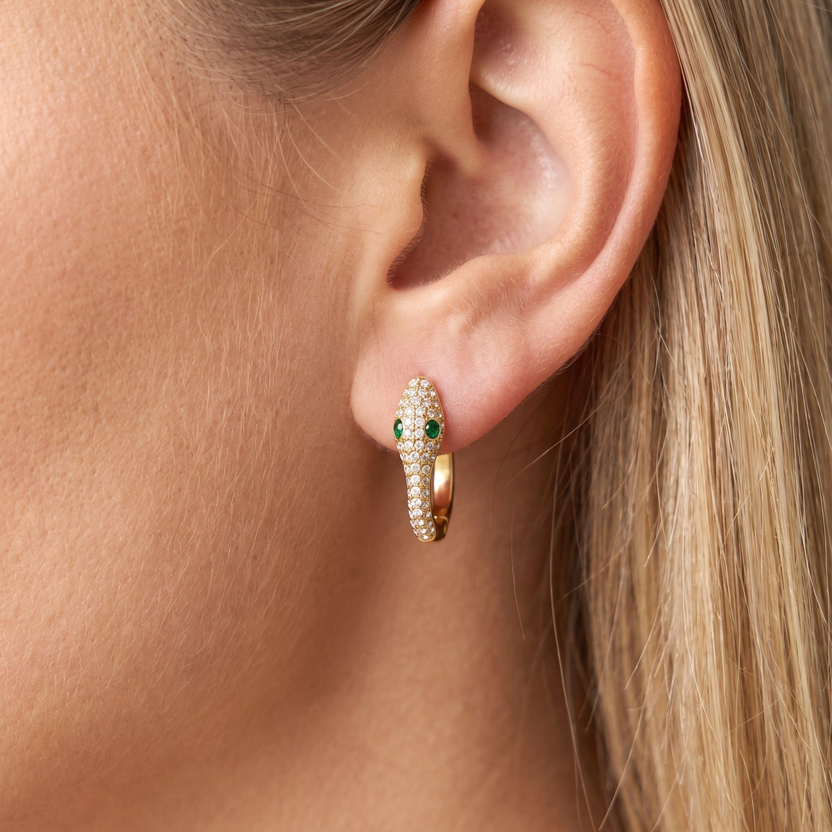 Woman wearing the Sabine pavé snake gold earrings on the ear
