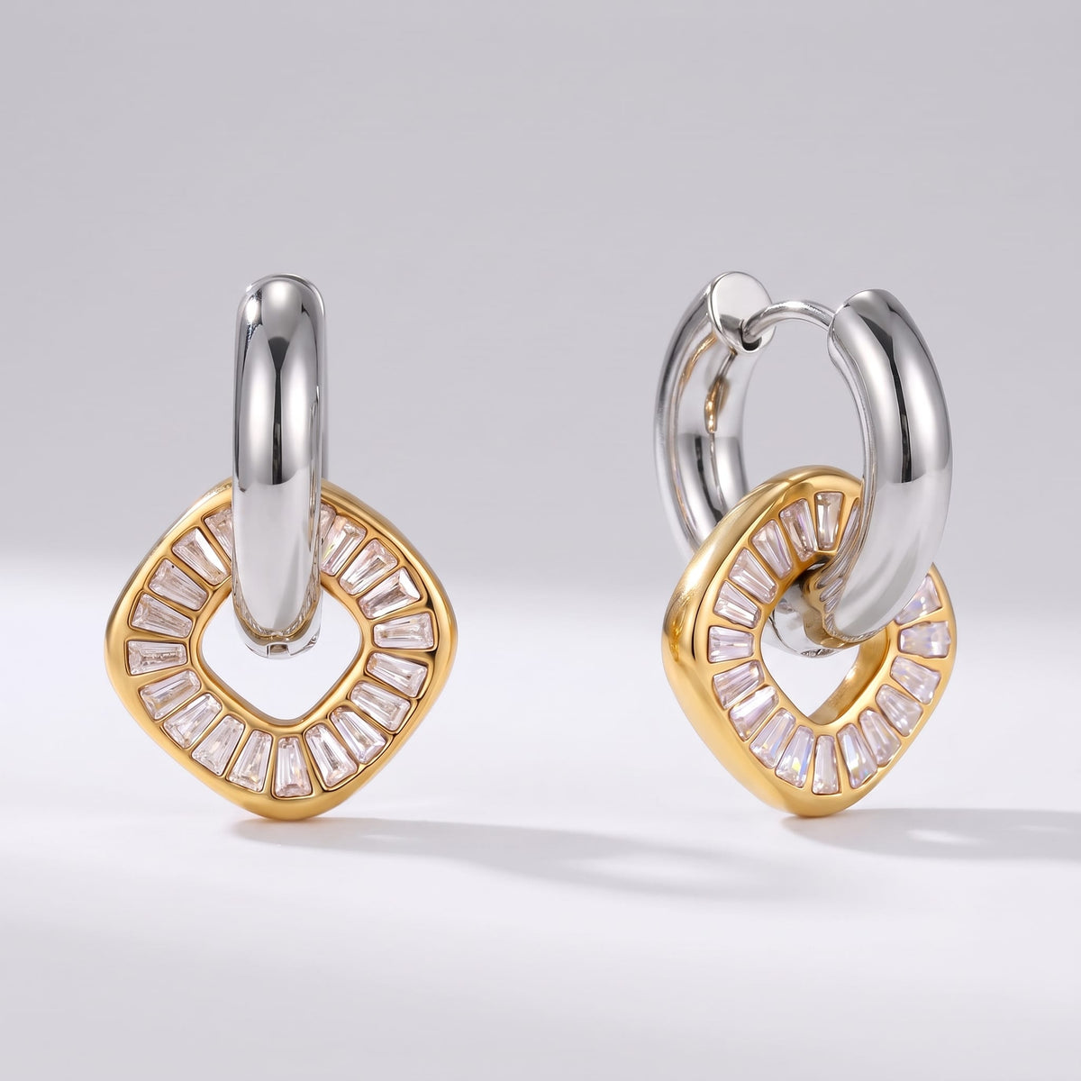 Salomé baguette charm two-tone earrings on a plain white background