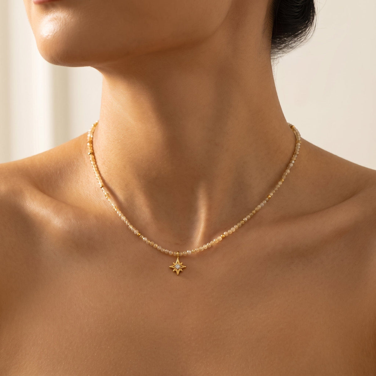 Woman wearing the Selene star gemstone gold necklace at the collarbone
