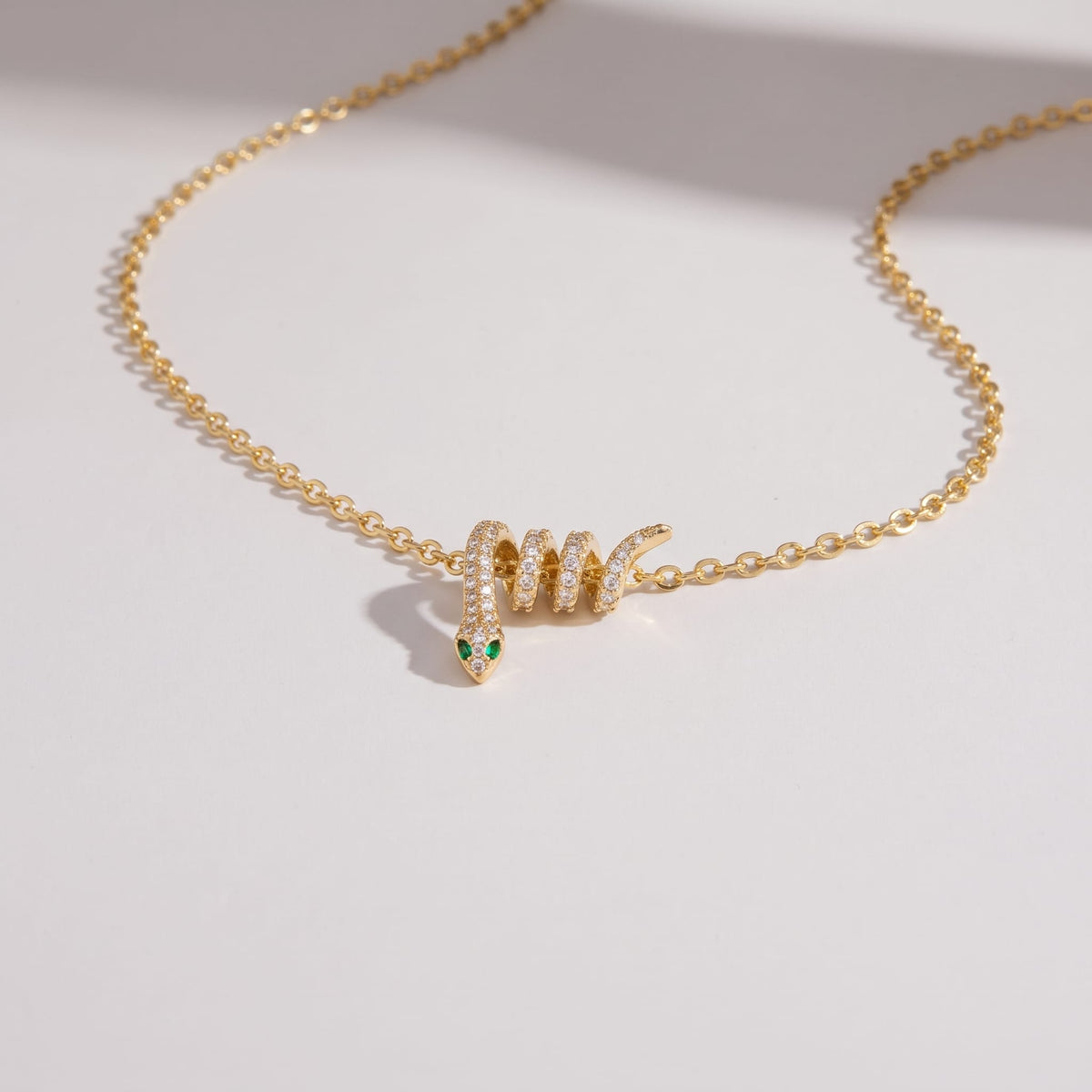 Serena pavé snake gold necklace on a plain light background with soft shadows