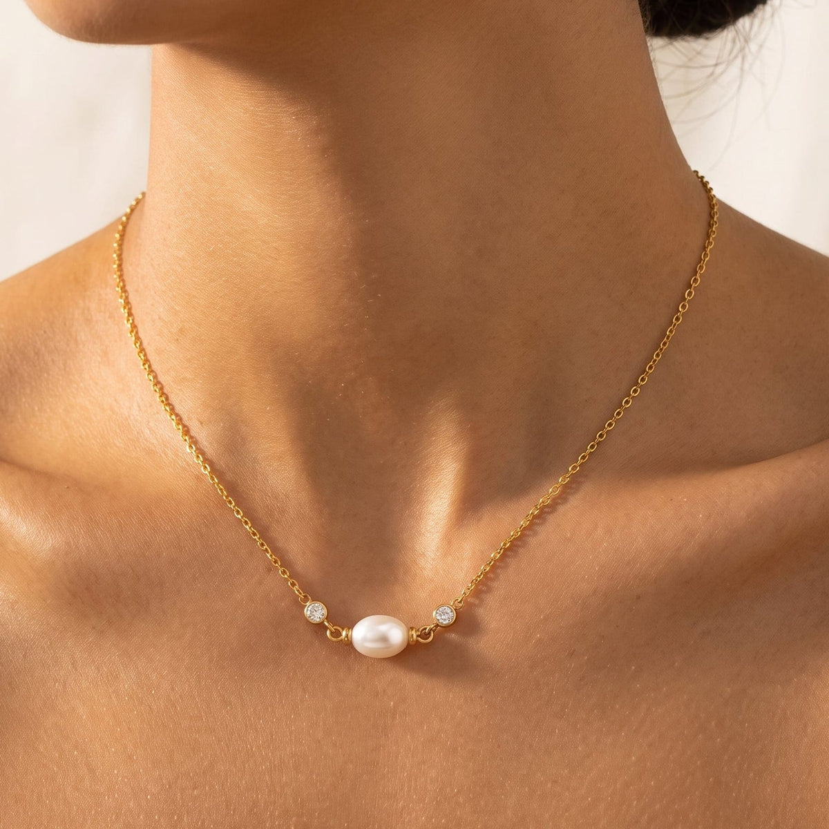 Woman wearing the Serena single pearl gold necklace at the collarbone