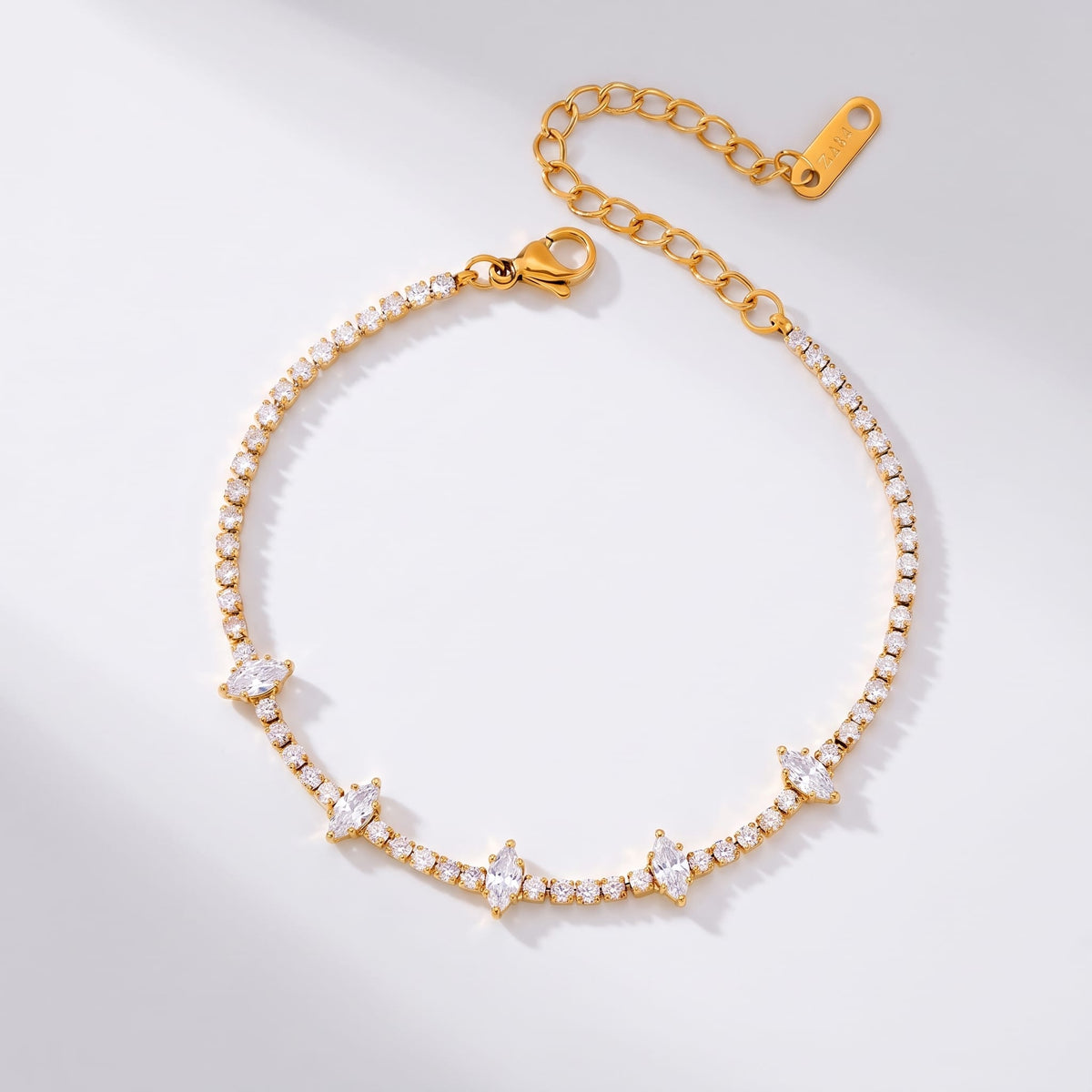 Sienna marquise tennis gold bracelet on a plain white surface with extension chain visible