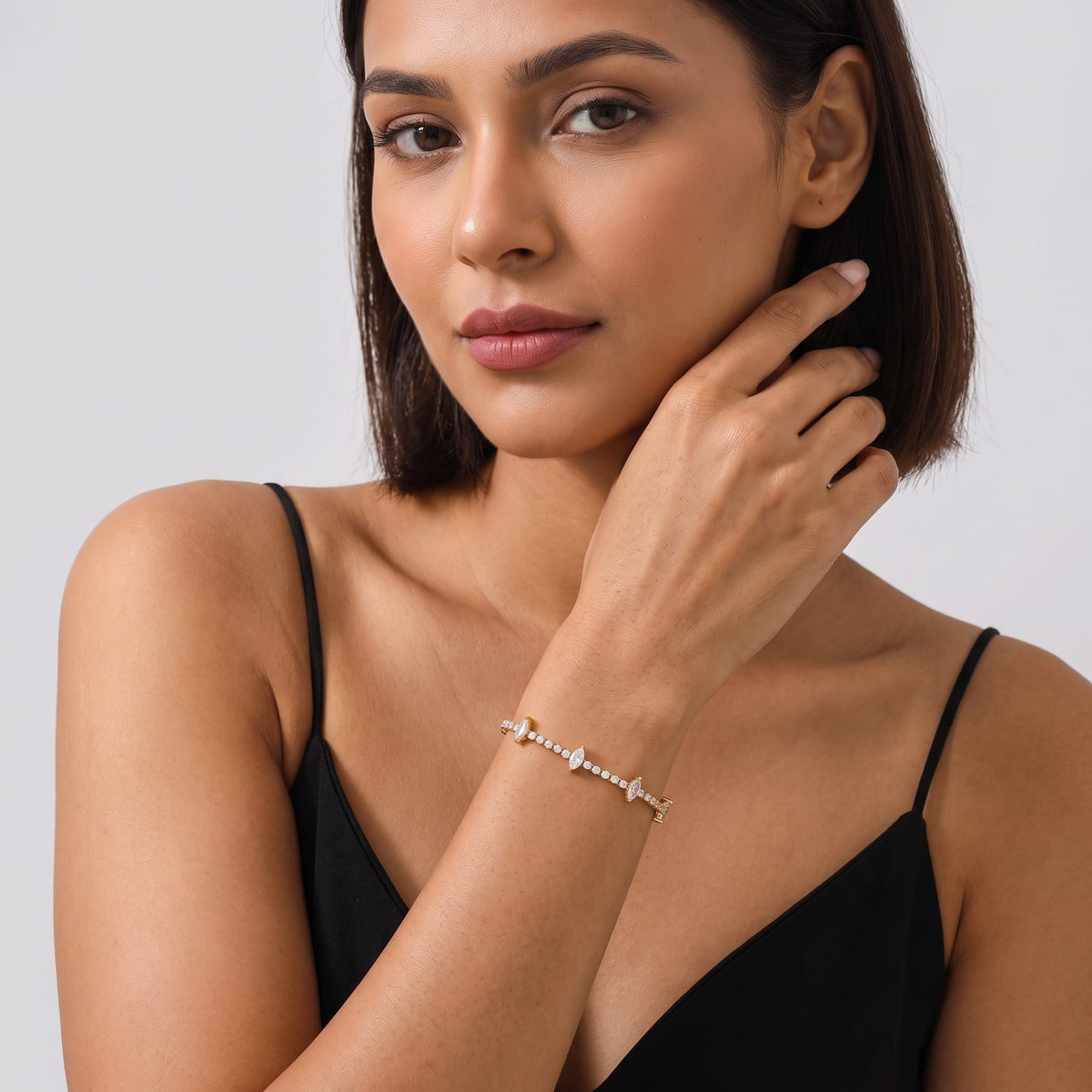 Woman wearing the Sienna marquise tennis gold bracelet on the wrist wearing a black tank top