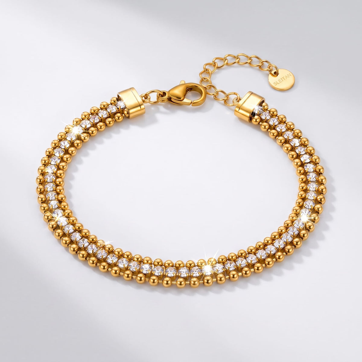 Sofia bead tennis gold bracelet on a plain white surface with extension chain visible