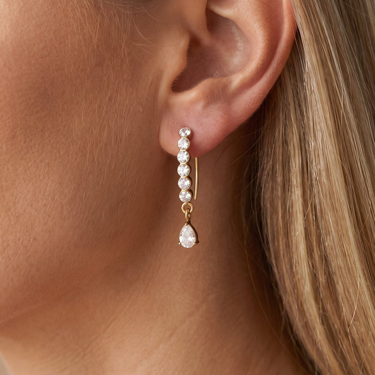 Woman wearing the Solène crystal drop gold earrings on the ear