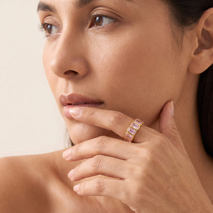 Woman wearing the Sophie pink baguette gold ring on the hand while looking away