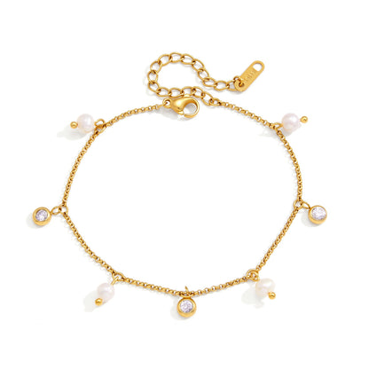 Teresa pearl charm gold bracelet laid open on white, pearls and crystal charms spaced around the chain