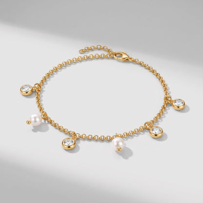 Teresa pearl charm gold bracelet on a plain white surface casting soft diagonal shadows