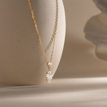 Valentina marquise drop necklace hanging against a stone vase in warm side light