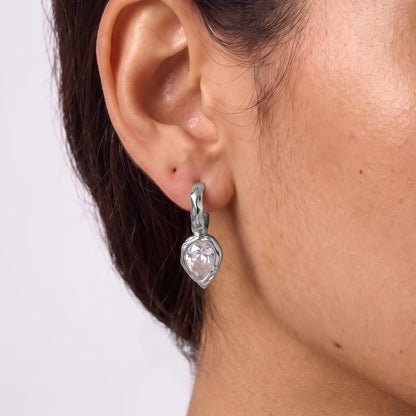 Woman wearing the Victoire hammered teardrop silver earrings on her ear in a close cropped view