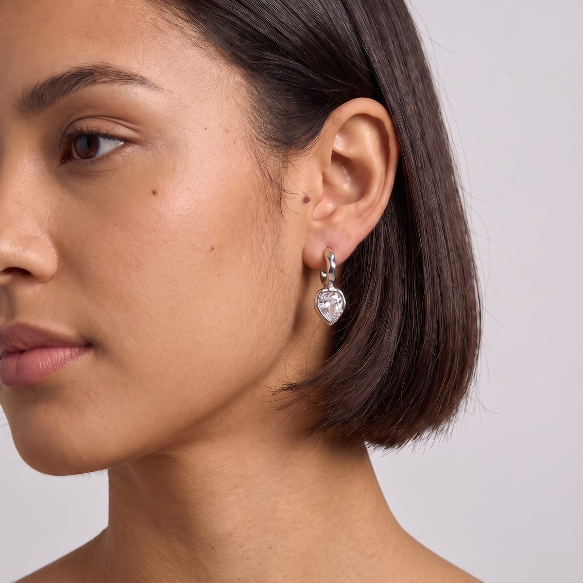 Woman wearing the Victoire hammered teardrop silver earrings on her ear with a short haircut