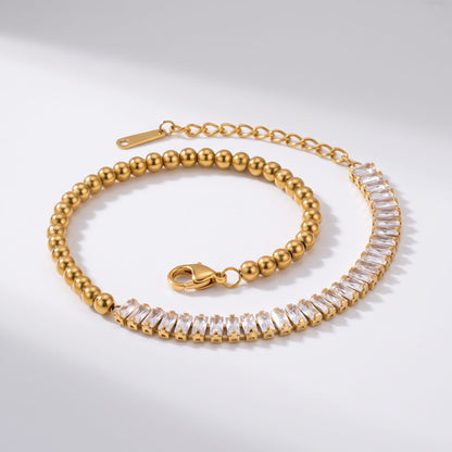 Vida baguette bead gold bracelet on a plain white surface