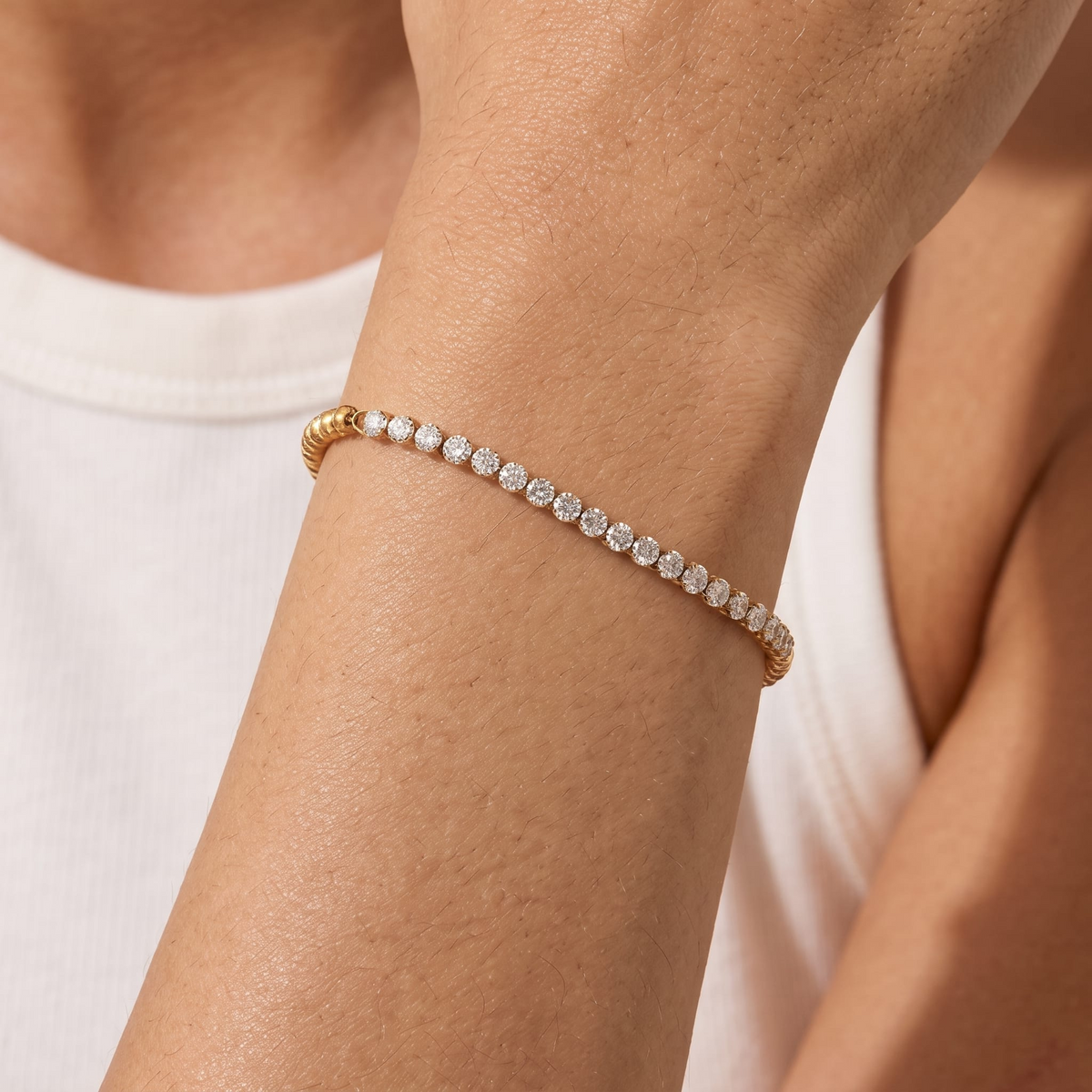 Woman wearing the Vida tennis bead gold bracelet on the wrist, featuring sparkling crystals