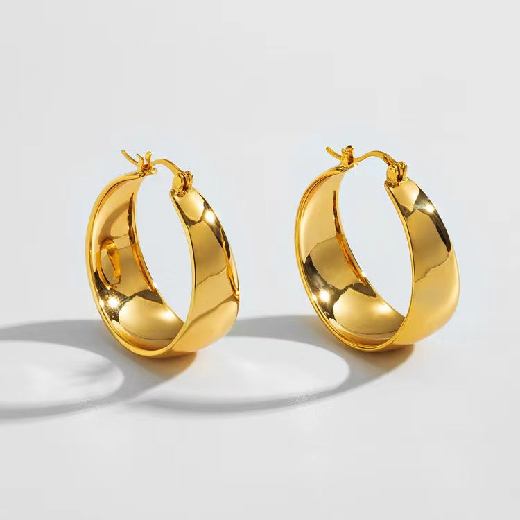 Vivienne wide arc gold earrings: a pair of wide polished hoops with a curved cambered profile and lever-back fastening