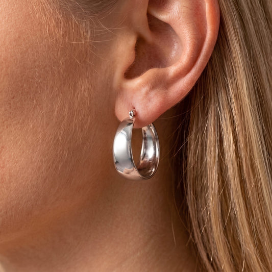 Close view of the Vivienne wide silver hoop with a smooth, high-shine finish