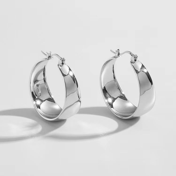 Vivienne wide arc silver earrings: a pair of wide polished hoops with a curved cambered profile and lever-back fastening