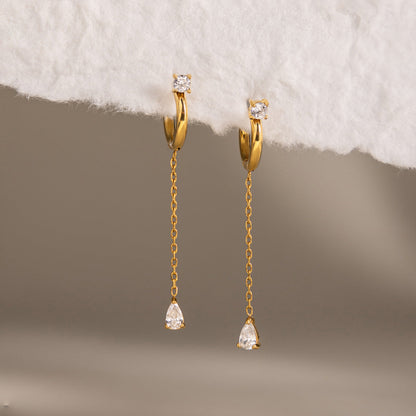 Yvette chain drop huggies hanging from white handmade paper over a soft gray backdrop